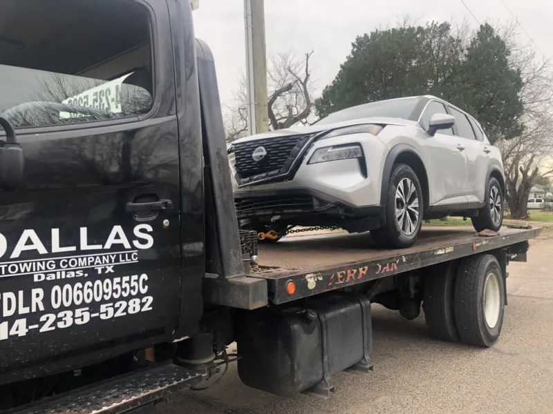 Damaged Nissan Rogue on a Dallas Towing Company flatbed in Dallas, TX