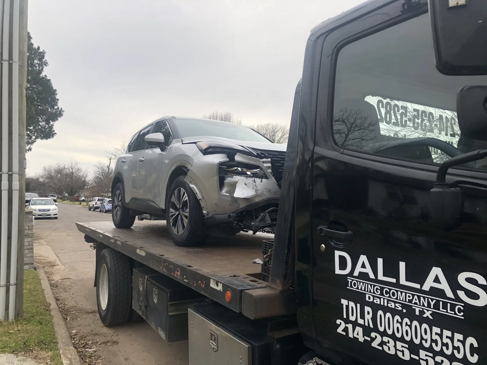 Damaged Nissan Rogue on a Dallas Towing Company flatbed after an accident
