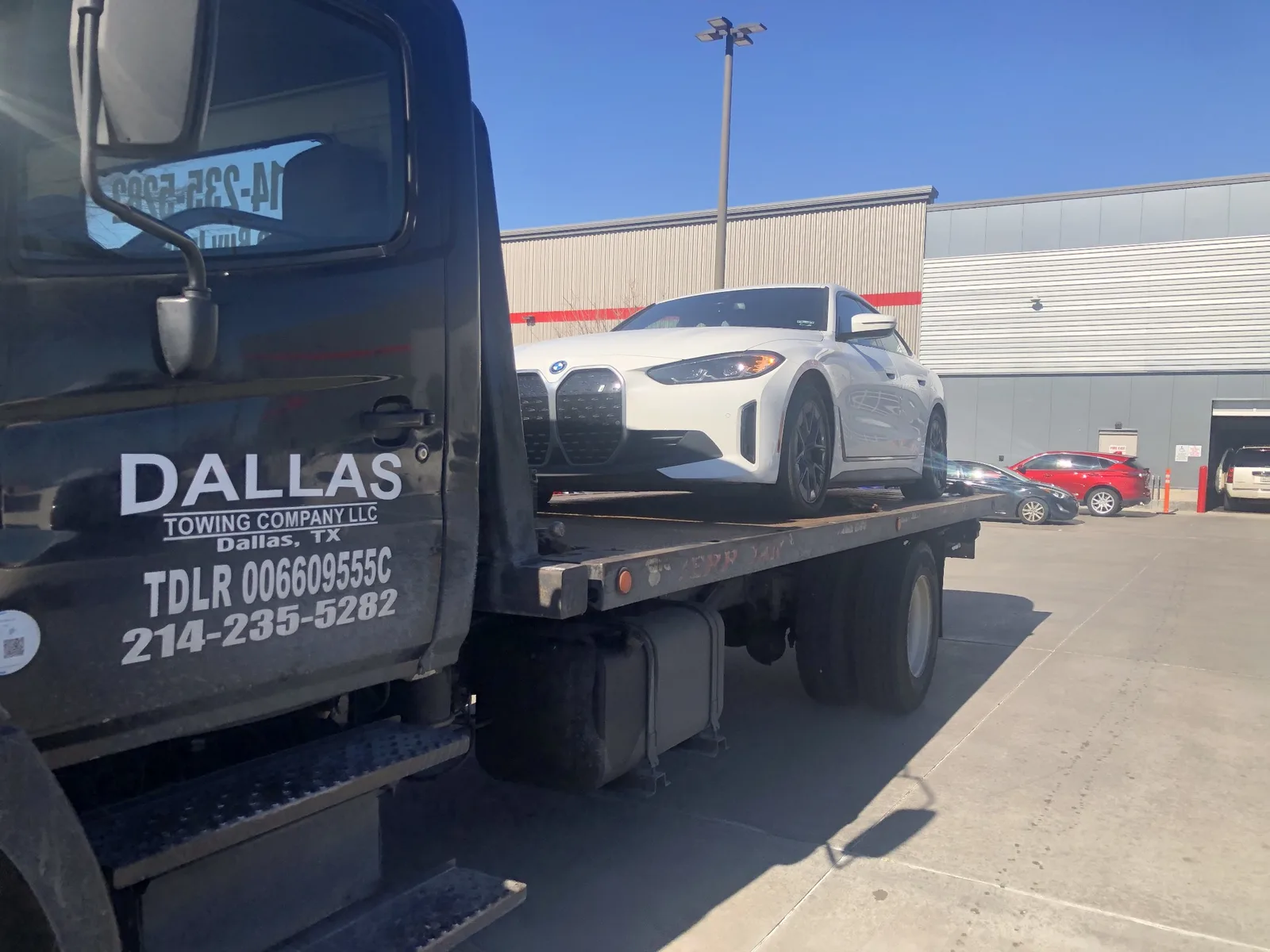 BMW i4 on a Dallas Towing Company flatbed in Dallas, TX