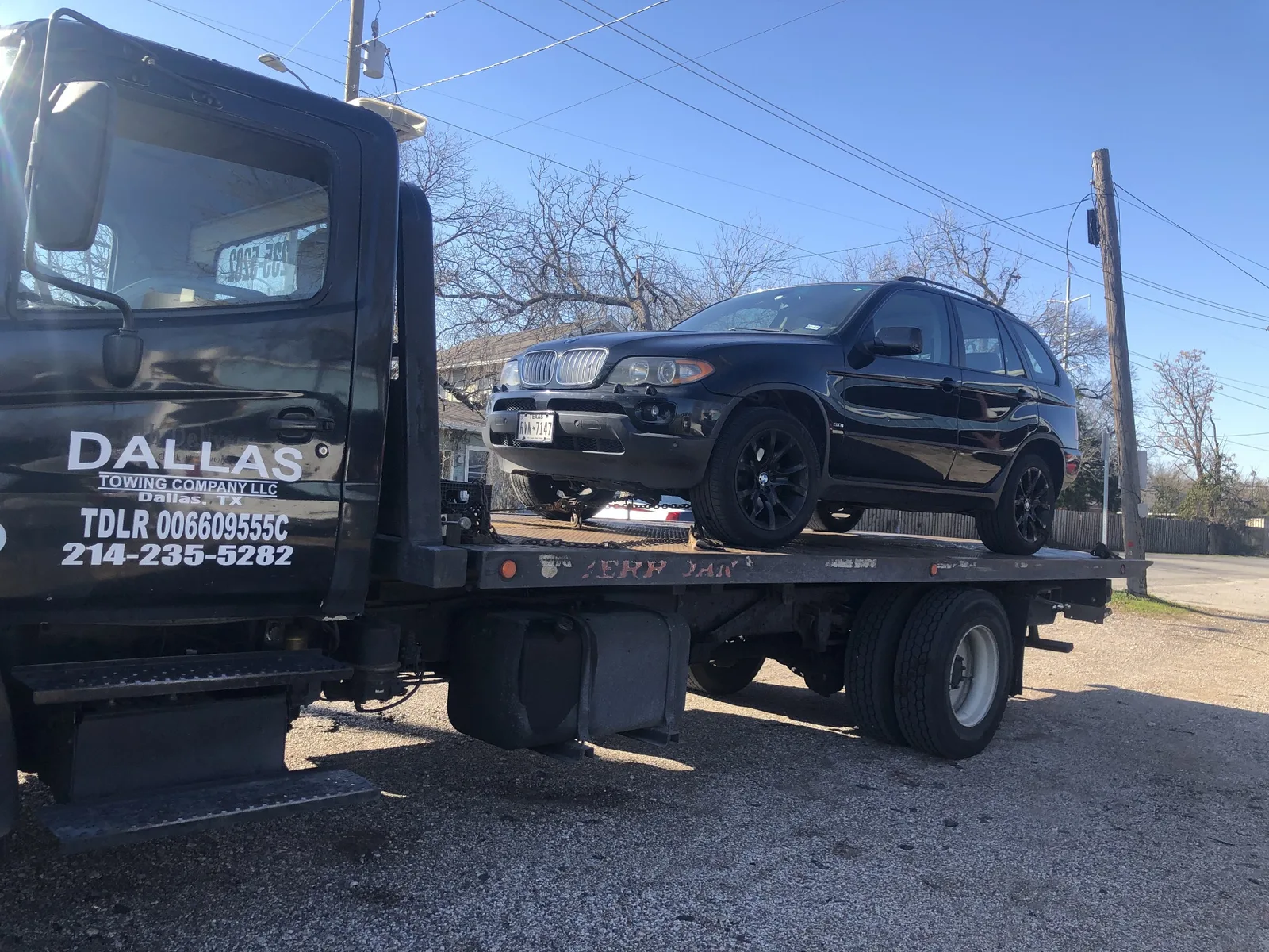 Black BMW X5 loaded on a Dallas Towing Company flatbed in Dallas, TX