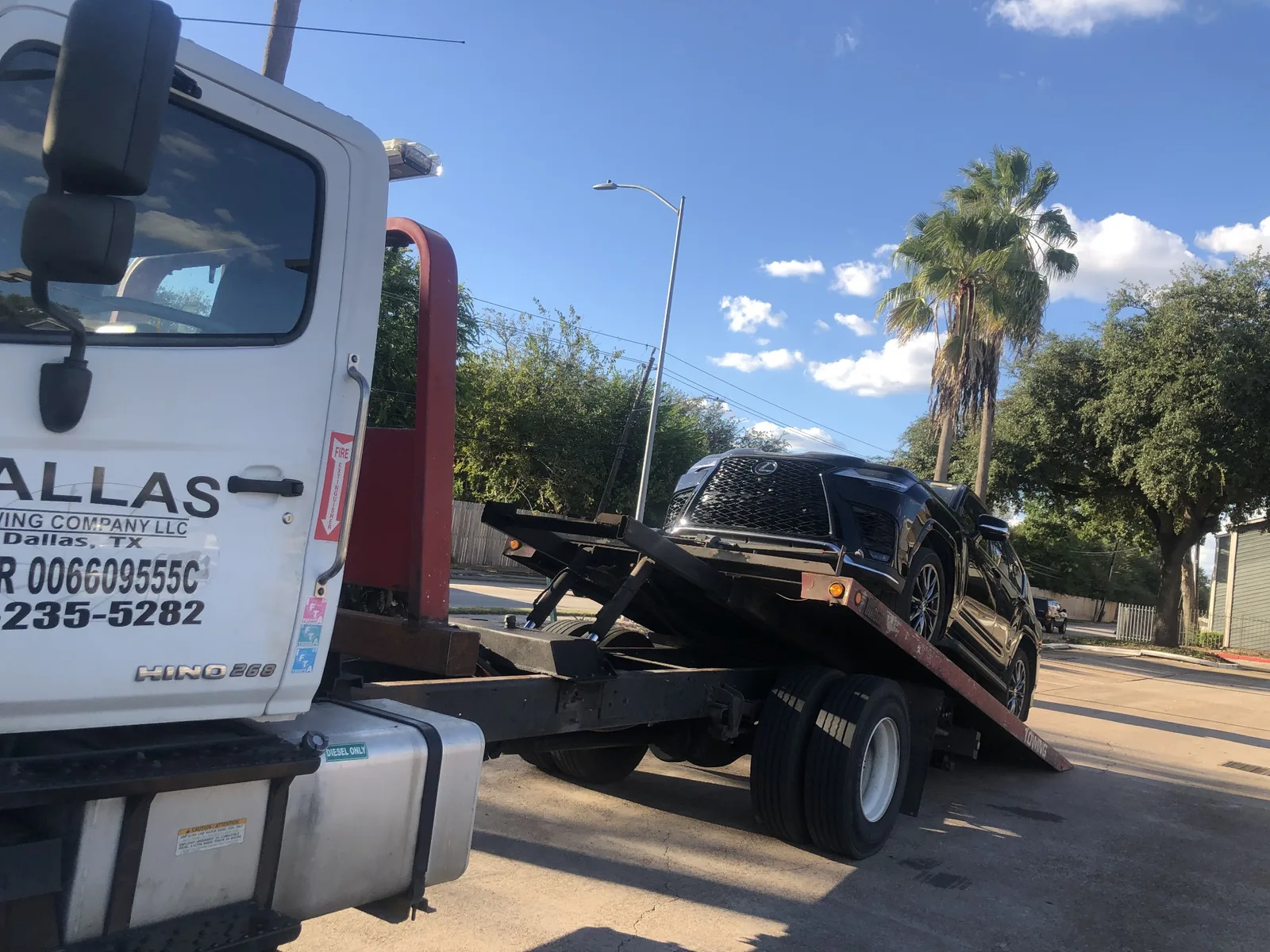 Dallas Towing Company flatbed loading a Lexus SUV in Dallas, TX