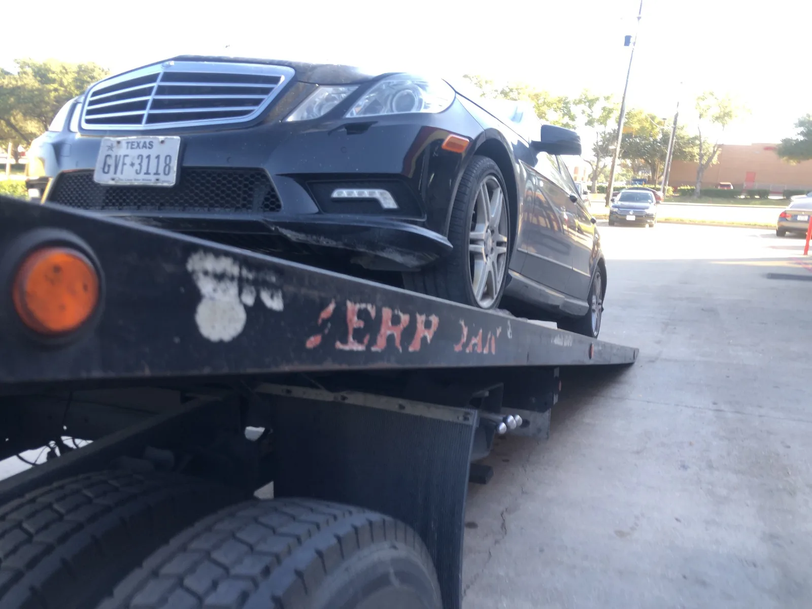 Mercedes-Benz sedan sliding onto a Dallas Towing Company flatbed