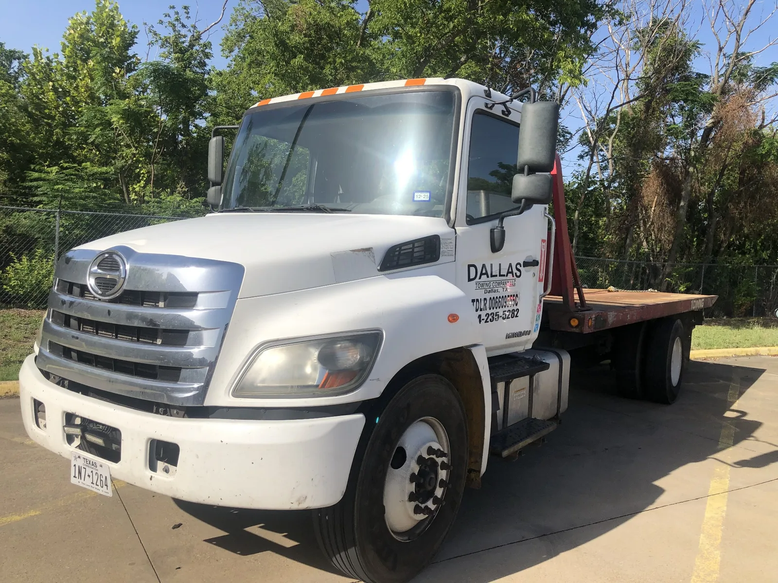 Dallas Towing Company white Hino flatbed tow truck in Dallas, TX