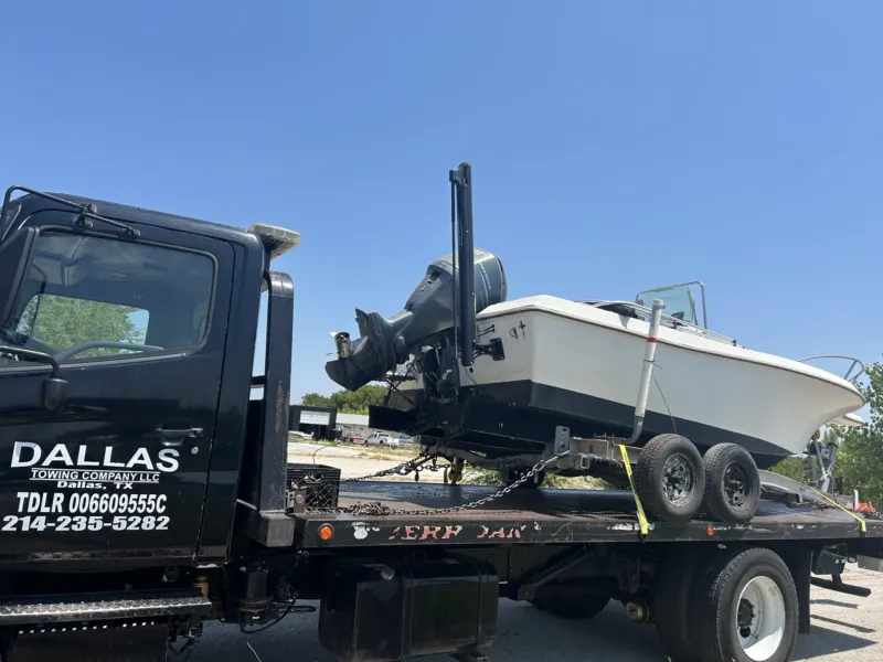 Boat and trailer on a Dallas Towing Company flatbed